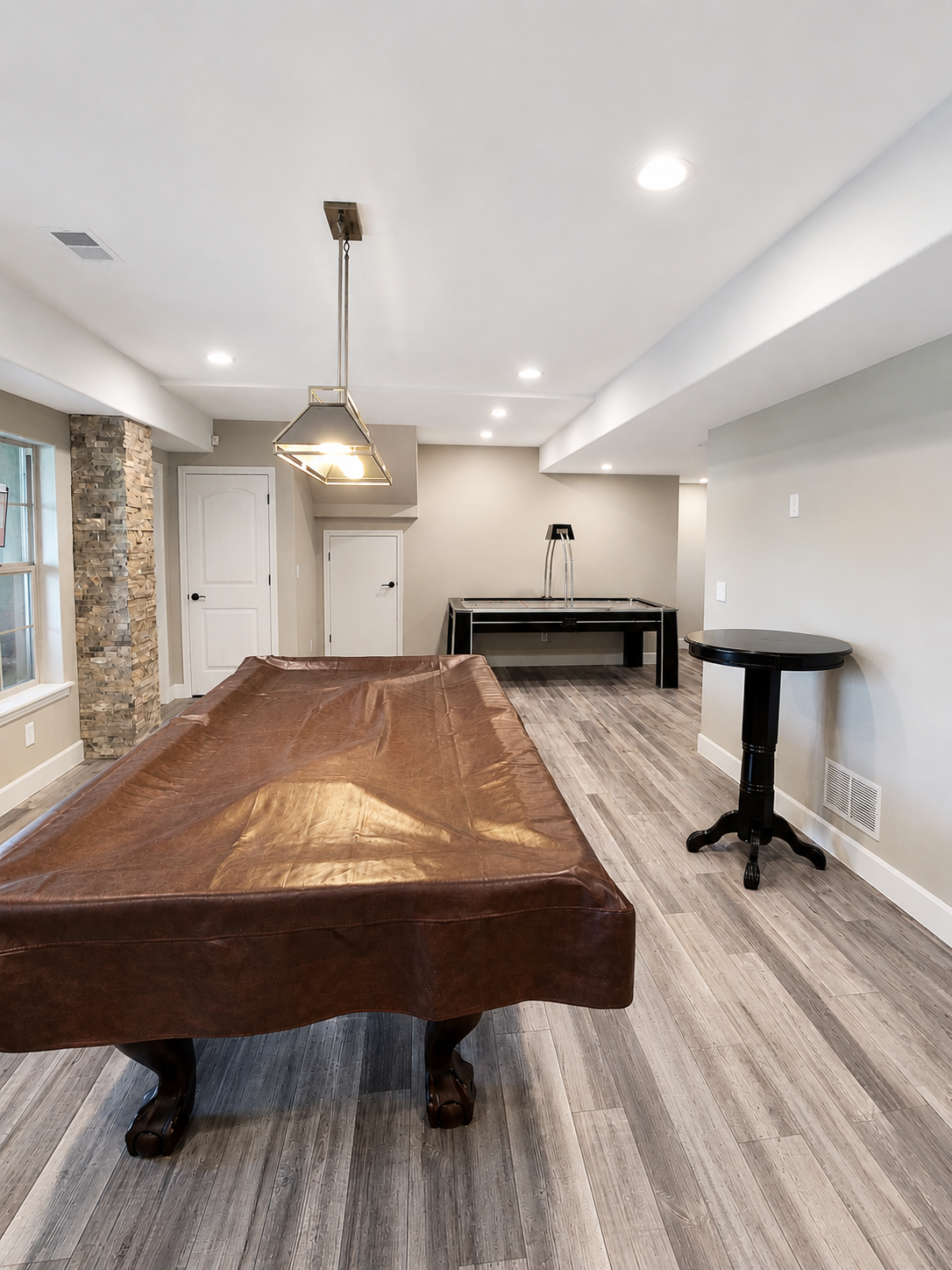 Finished basementrecreation room featuring luxury vinyl plank flooring, recessed lighting and dedicated entertainment zones. Quailty finishes create a comfortable space for family use.