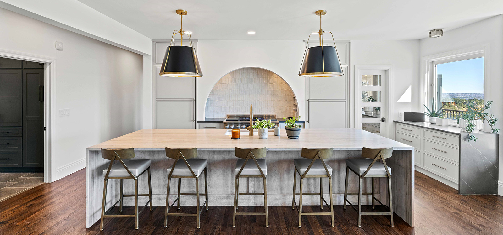 Kitchen remodel with large granite island, arched cooking vent, and premier lighting.