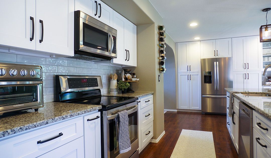 A kitchen remodel in Colorado Springs. White cabinets, granite countertop, stainless steel appliances.