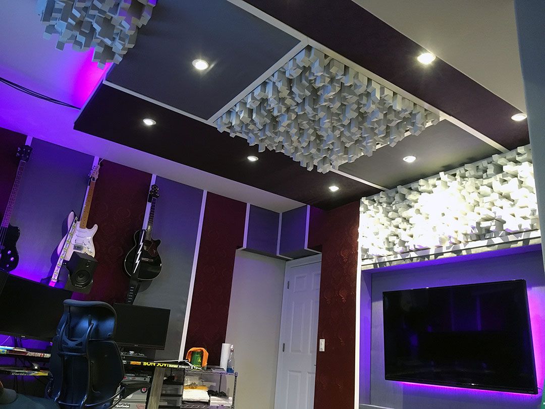 Home theater and recording studio combination. Skyline diffusors, sound clouds, absorption panels, guitars hanging on the wall, and computer work center.